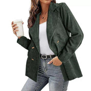 Giacca donna verde scuro in velluto a coste, doppio petto, abbinata a jeans e top bianco. Moda autunnale casual elegante.