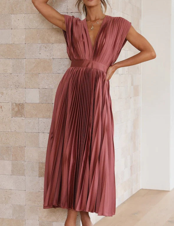 Abito lungo plissettato color terracotta, scollatura a V, senza maniche, elegante e moderno, perfetto per eventi formali e serate speciali.