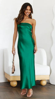 Abito lungo verde smeraldo in raso, senza spalline, indossato da una donna sorridente. Elegante e adatto per eventi serali o cerimonie.