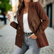 Giacca marrone a coste su donna con caffè in mano, jeans e cintura nera. Moda autunnale casual in strada urbana.