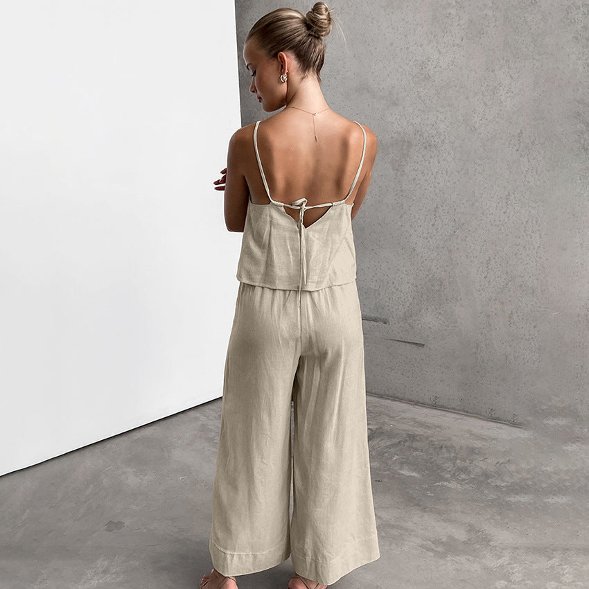 Donna in tuta beige senza maniche, vista posteriore, su sfondo grigio. Moda estiva, abbigliamento casual elegante, tessuto leggero.