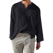Camicia uomo nera in lino, maniche lunghe, scollo a V, taschino frontale, abbinata a pantaloni a righe. Stile casual elegante.