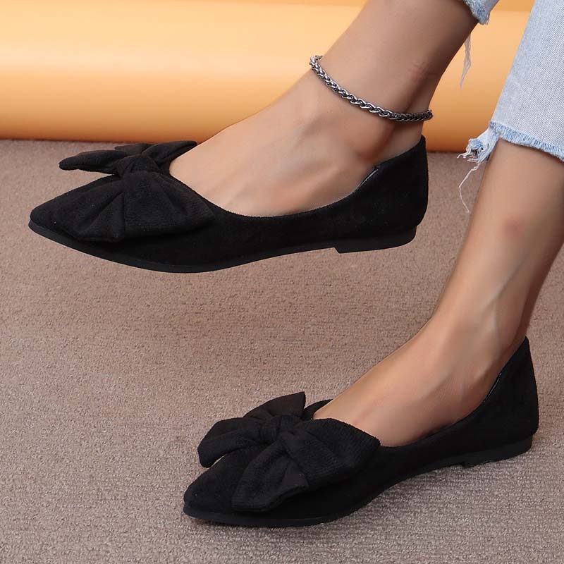 Scarpe ballerine nere da donna con fiocco, indossate con jeans chiari. Eleganti e comode, ideali per moda casual e look quotidiano.