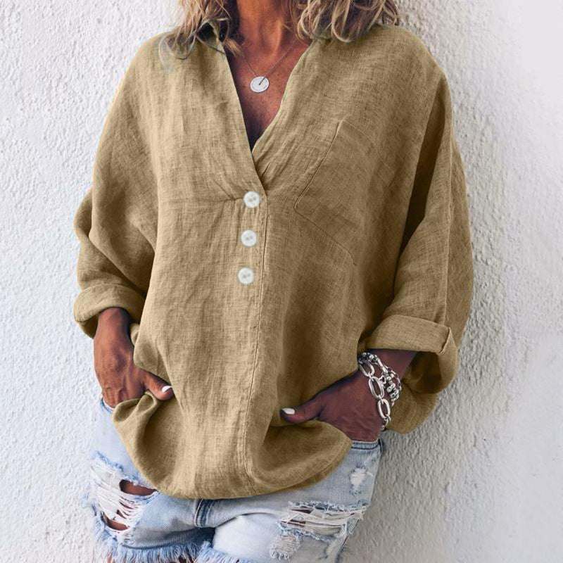 Camicia donna in lino beige con bottoni bianchi, maniche lunghe arrotolate, abbinata a jeans strappati. Look casual e alla moda.