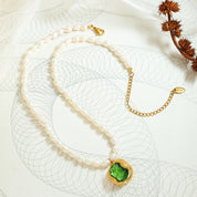 Collana di perle con ciondolo verde in oro, design elegante su sfondo artistico. Gioielli di lusso, accessori moda, regalo perfetto.