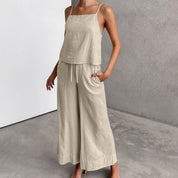 Donna in tuta beige in lino, pantaloni larghi e top senza maniche, stile casual estivo. Abbigliamento femminile elegante e confortevole.