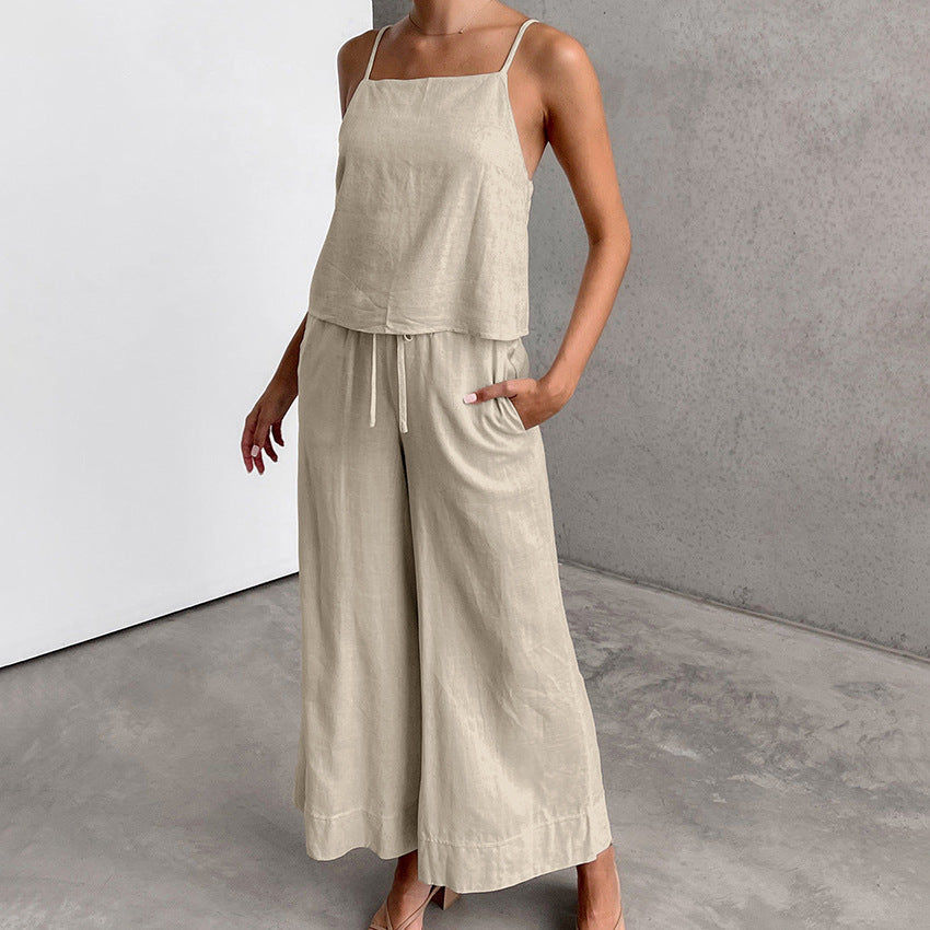 Donna in tuta beige in lino, pantaloni larghi e top senza maniche, stile casual estivo. Abbigliamento femminile elegante e confortevole.