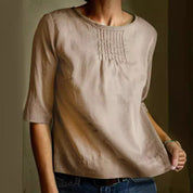 Blusa donna beige in cotone, maniche a tre quarti, scollo rotondo, dettagli plissettati, stile casual elegante, perfetta per ogni occasione.
