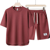 Set coordinato uomo in cotone rosso, composto da t-shirt a maniche corte e pantaloncini con coulisse. Abbigliamento casual estivo.