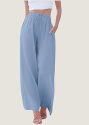 Pantaloni palazzo donna azzurri, vita alta, tessuto leggero, tasche laterali, abbinati a top bianco. Moda estiva casual elegante.