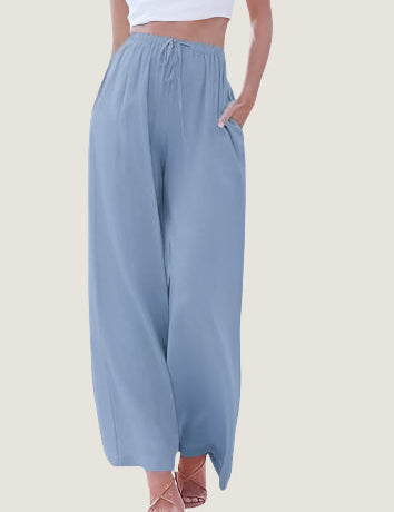 Pantaloni palazzo donna azzurri, vita alta, tessuto leggero, tasche laterali, abbinati a top bianco. Moda estiva casual elegante.