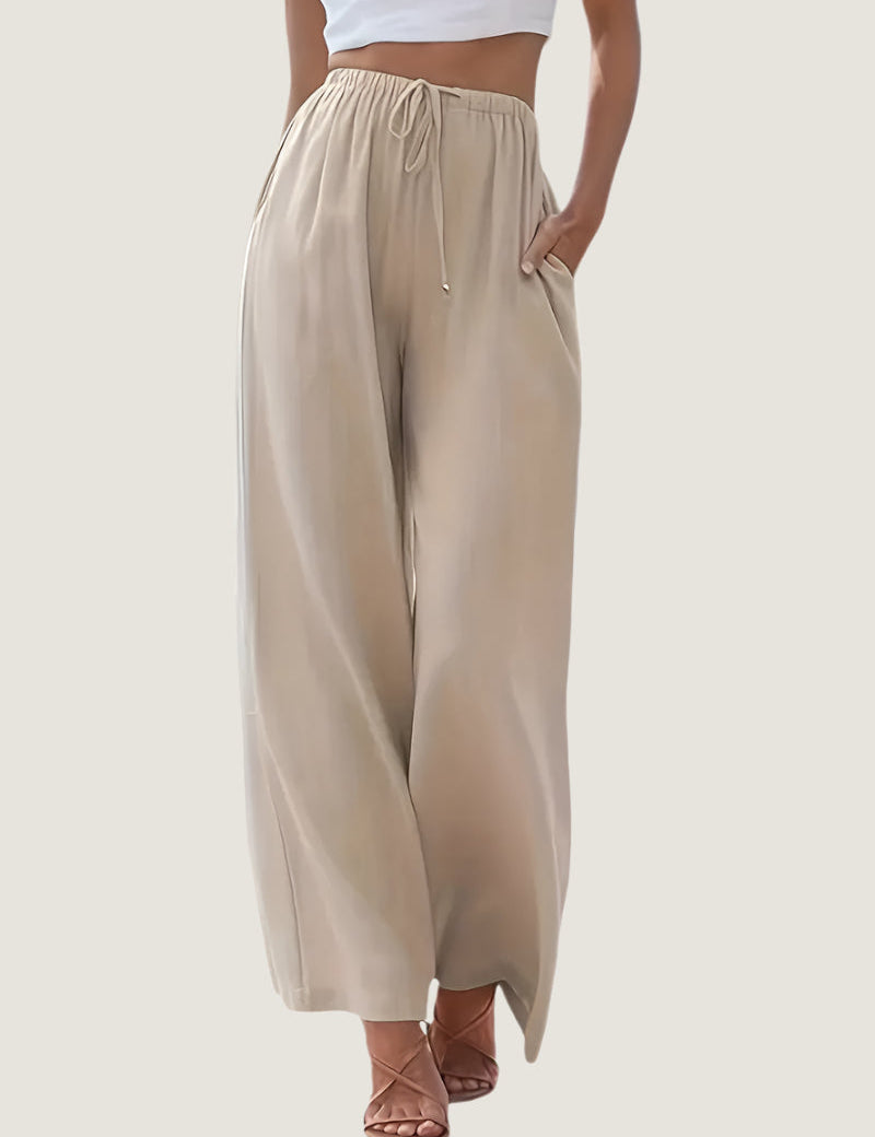 Pantaloni palazzo beige da donna, vita alta con coulisse, tessuto leggero, tasche laterali, abbinati a top bianco. Eleganti e comodi per l'estate.
