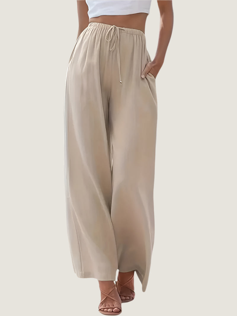 Pantaloni palazzo beige da donna, vita alta con coulisse, tessuto leggero, tasche laterali, abbinati a top bianco. Eleganti e comodi per l'estate.