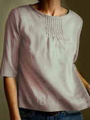 Maglietta donna in lino beige, maniche a tre quarti, scollo rotondo, dettagli pieghettati sul petto. Elegante e casual, perfetta per ogni occasione.