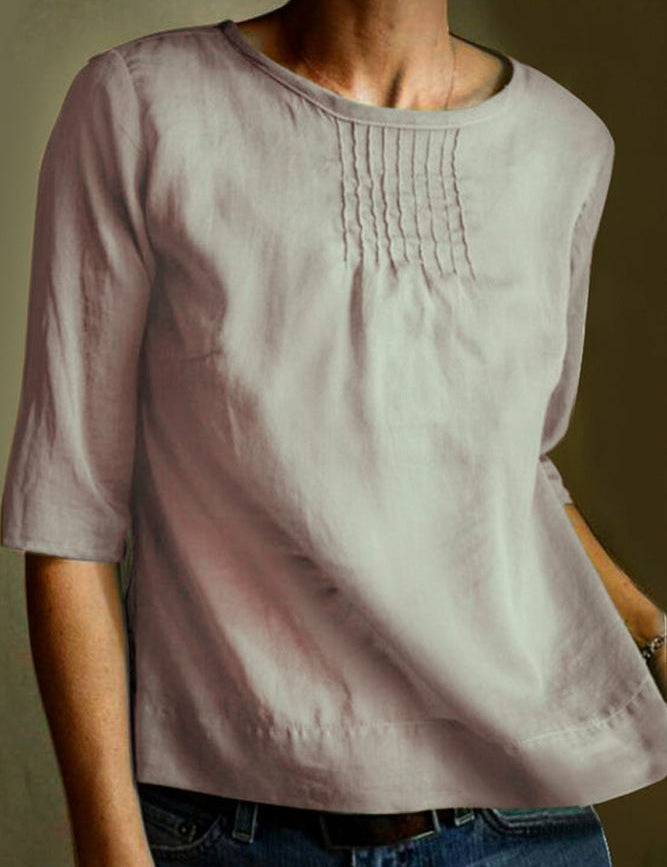 Maglietta donna in lino beige, maniche a tre quarti, scollo rotondo, dettagli pieghettati sul petto. Elegante e casual, perfetta per ogni occasione.