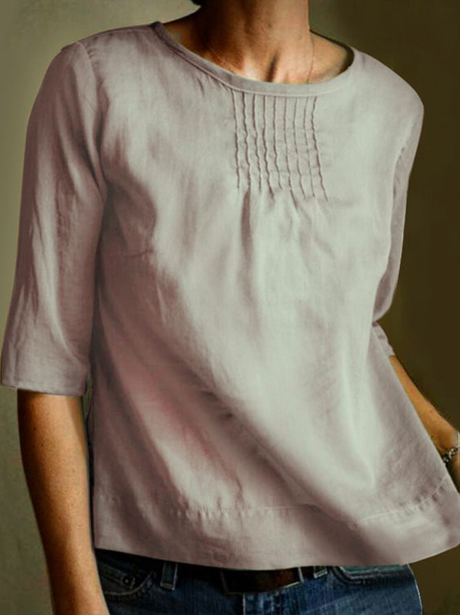 Maglietta donna in lino beige, maniche a tre quarti, scollo rotondo, dettagli pieghettati sul petto. Elegante e casual, perfetta per ogni occasione.