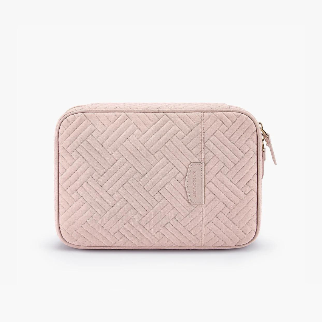 Custodia rosa trapuntata in tessuto con motivo geometrico, chiusura a zip dorata, ideale per accessori da viaggio. Design elegante e funzionale.