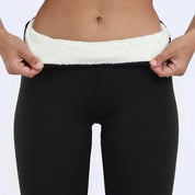 Pantaloni termici neri da donna con fodera in pile bianco, ideali per l'inverno. Comfort e calore, perfetti per attività all'aperto.