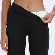 Pantaloni termici neri da donna, vita alta, con interno in pile bianco, ideali per l'inverno e attività all'aperto.
