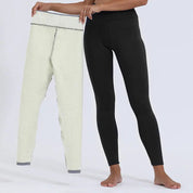 Donna in leggings neri tiene leggings in pile bianco, abbigliamento invernale caldo, moda donna, pantaloni termici, comfort e stile.