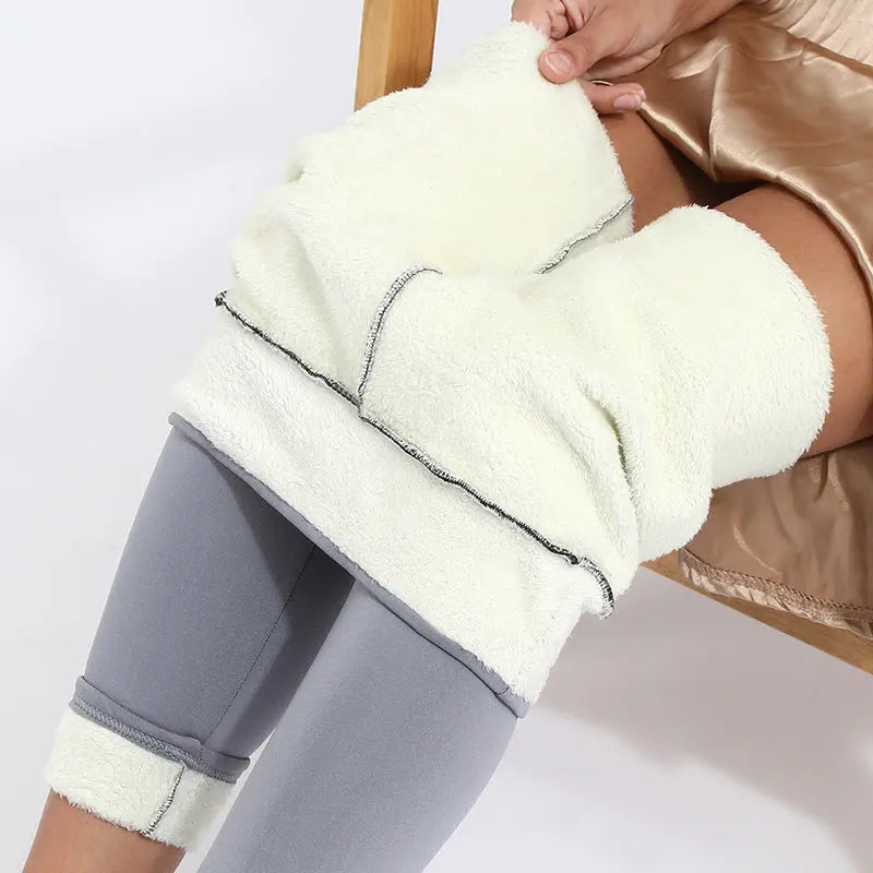 Pantaloni termici in pile bianco, indossati sopra leggings grigi. Ideali per l'inverno, offrono calore e comfort. Perfetti per attività all'aperto.