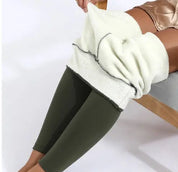 Donna indossa leggings termici in pile bianco e verde, seduta su sedia. Abbigliamento invernale caldo, moda donna, comfort e stile.