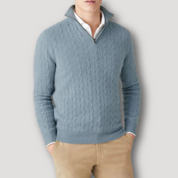 Maglione uomo blu con zip, lavorazione a trecce, collo alto, abbinato a pantaloni beige. Elegante e casual, ideale per l'autunno.
