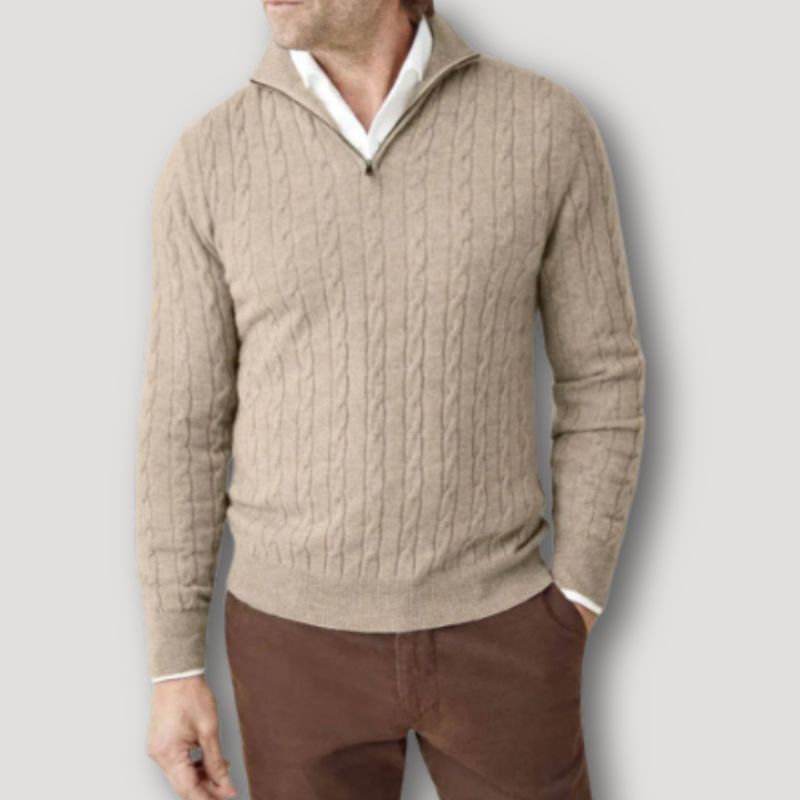 Maglione uomo beige a trecce con zip, collo alto, indossato su camicia bianca e pantaloni marroni. Elegante e casual, moda autunno inverno.