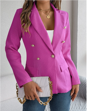 Giacca blazer donna fucsia elegante, doppio petto, bottoni dorati, abbinata a borsa a tracolla con catena dorata. Look moda femminile chic.