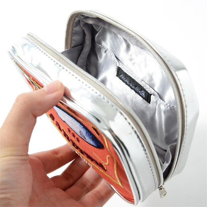 Astuccio portamonete in pelle argentata con interno foderato in tessuto grigio, chiusura a zip, design colorato. Accessorio moda elegante.