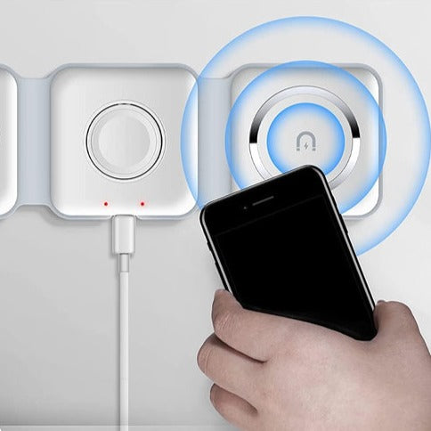 Mano che avvicina smartphone a caricatore wireless magnetico bianco su parete, con cavo USB. Tecnologia di ricarica rapida e innovativa.