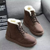 Stivali invernali marroni da uomo con fodera in pelliccia sintetica, su divano grigio. Scarpe calde, moda casual, perfette per il freddo.