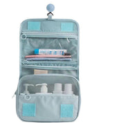 Astuccio da viaggio appeso, blu, con scomparti trasparenti e tasche a rete, ideale per cosmetici e articoli da toeletta. Organizzazione pratica.