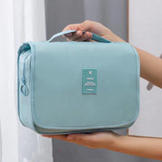 Borsa da viaggio azzurra con manico, chiusura a zip, ideale per organizzare accessori da bagno. Design compatto e portatile.