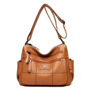 Borsa a tracolla in pelle marrone, design elegante con tasche multiple e cerniere, ideale per moda donna. Accessorio versatile e di tendenza.