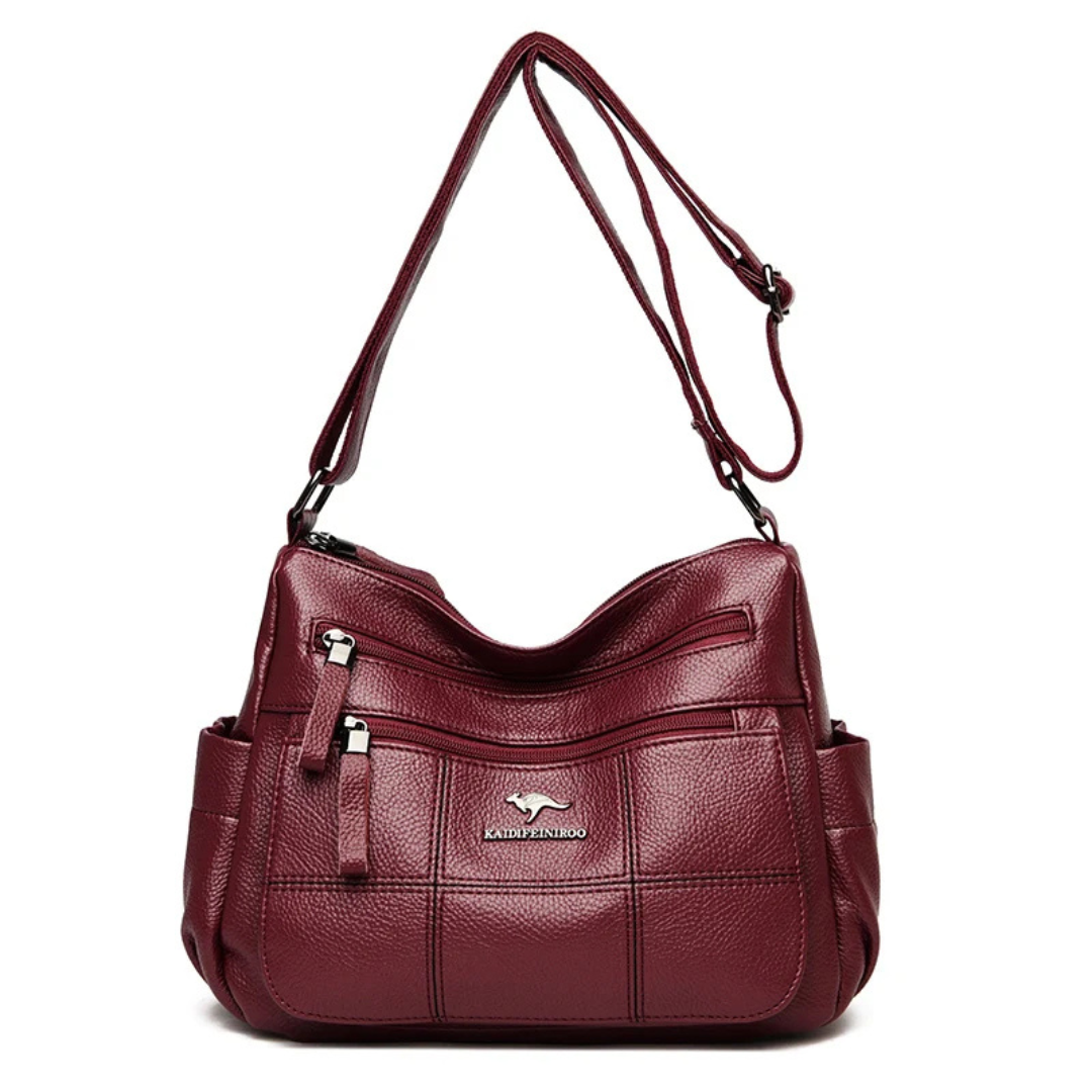 Borsa a tracolla in pelle rossa con tasche multiple e cerniere, design elegante e pratico, ideale per donna. Accessorio moda versatile.