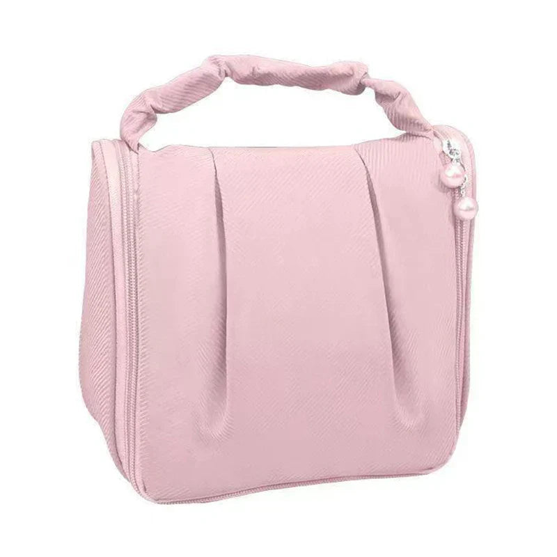 Borsa cosmetica rosa con manico imbottito, chiusura a zip e decorazione con perle. Ideale per trucco e accessori da viaggio.