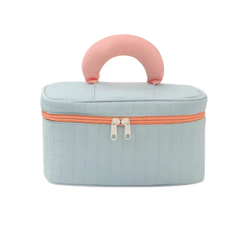 Borsa cosmetica da viaggio azzurra con manico rosa, chiusura a zip arancione, design elegante e compatto, ideale per organizzare trucchi e accessori.