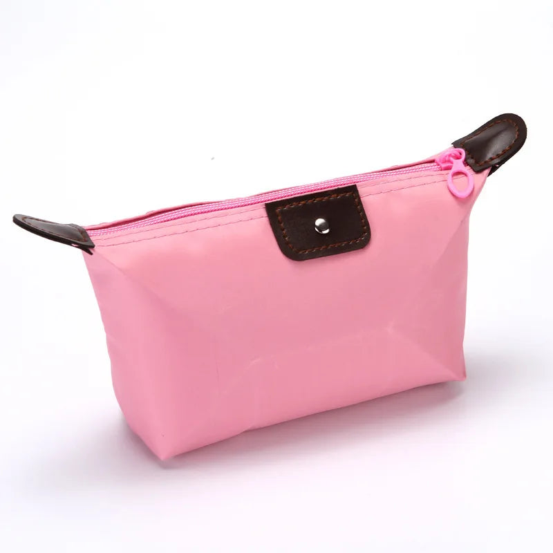 Borsa cosmetica rosa in nylon con cerniera, dettagli in pelle marrone, ideale per trucco e accessori da viaggio. Design elegante e pratico.