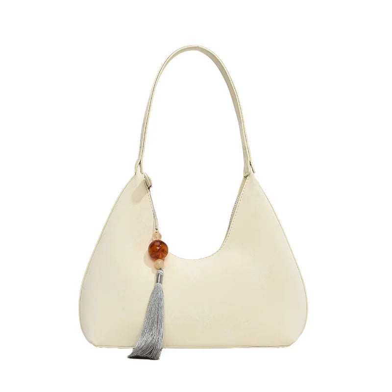Borsa a spalla in pelle bianca con ciondolo decorativo e nappina grigia, design elegante e moderno, accessorio moda donna.