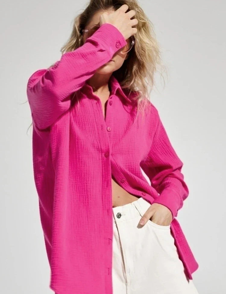 Camicia donna fucsia in cotone, maniche lunghe, abbinata a pantaloni bianchi. Moda casual, stile primaverile, tendenza abbigliamento femminile.