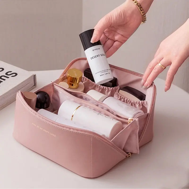 Astuccio da viaggio rosa con scomparti, contenente cosmetici e prodotti per la cura della pelle. Organizzatore trucco elegante e funzionale.