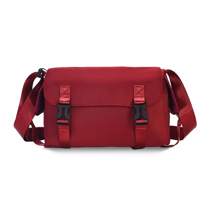 Borsa a tracolla rossa unisex, design moderno, con chiusure a fibbia, ideale per viaggi e uso quotidiano. Materiale resistente e spazioso.