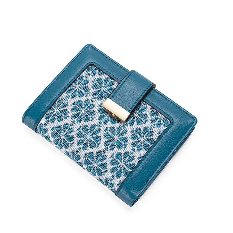 Portafoglio donna in pelle blu con motivo floreale, chiusura a scatto dorata. Accessorio moda elegante, ideale per organizzare carte e contanti.