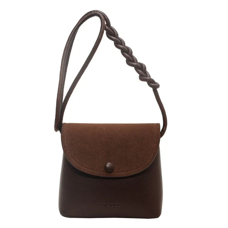 Borsa a tracolla in pelle marrone scuro con patta in camoscio e chiusura a bottone, manico intrecciato. Elegante accessorio moda donna.