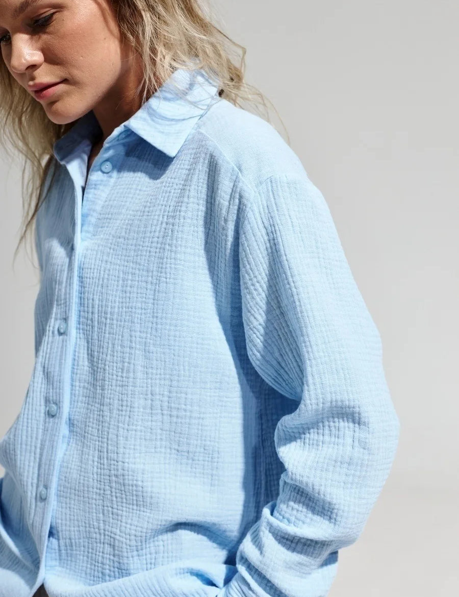 Camicia donna azzurra in cotone leggero, maniche lunghe, colletto classico, stile casual. Ideale per look estivi e primaverili.