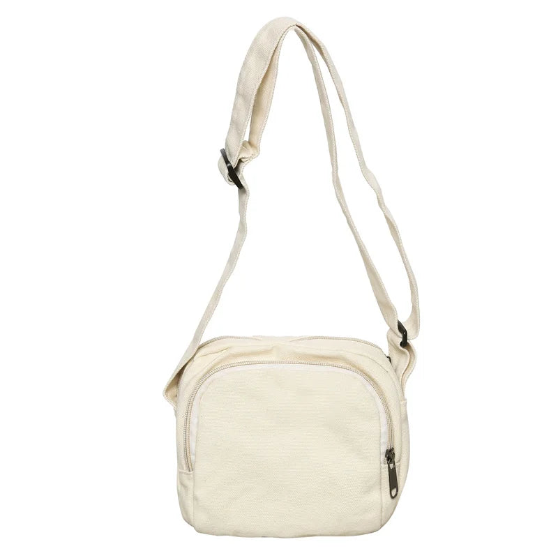 Borsa a tracolla in tela bianca, design minimalista, con cerniera frontale e tracolla regolabile. Perfetta per uso quotidiano e casual.
