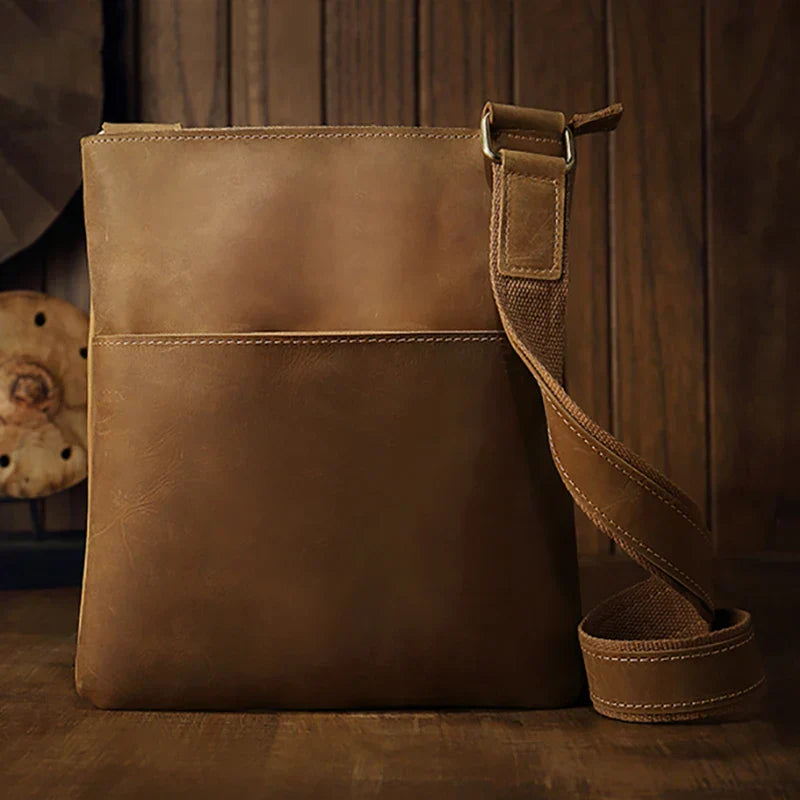 Borsa a tracolla in pelle marrone, design elegante e minimalista, perfetta per uomo e donna. Accessorio moda versatile e di alta qualità.