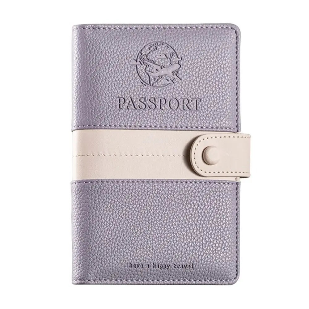 Custodia passaporto in pelle viola con chiusura a bottone beige, design elegante con incisione aereo, ideale per viaggiatori.