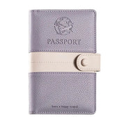 Custodia passaporto in pelle viola con chiusura a bottone beige, design elegante con incisione aereo, ideale per viaggiatori.